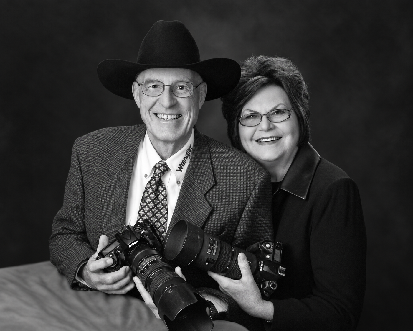 Jim and Marilyn Svoboda posed together, each holding a Nikon camera